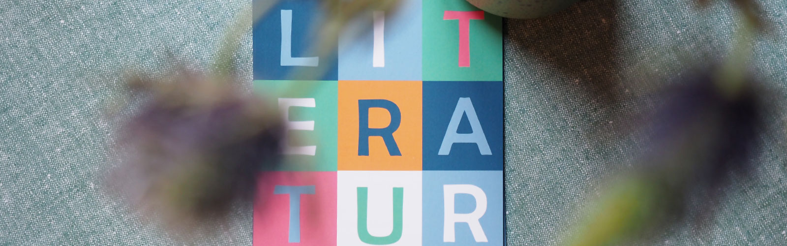 Bunter Flyer vom Literaturkontor auf einem Tisch